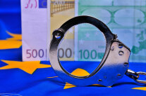 Handschellen vor Euro-Banknote 