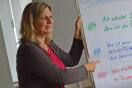 Frau zeigt auf Text auf einer Flip-Chart