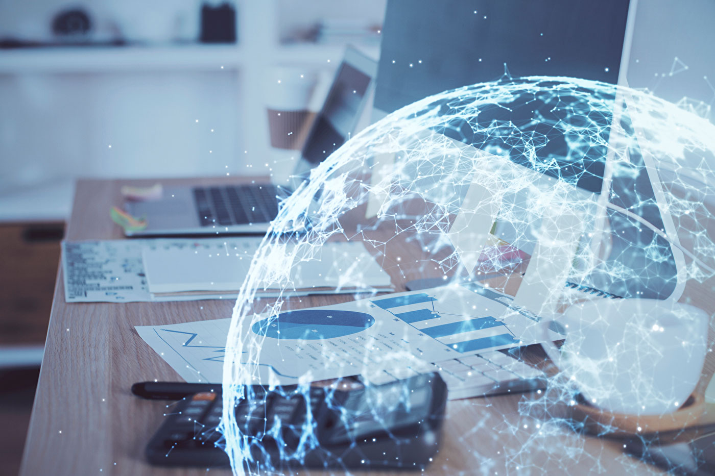 vernetzter Globus vor einem Arbeitsplatz mit Laptop
