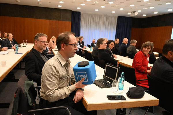 Mann spricht in Mikrofon-Würfel